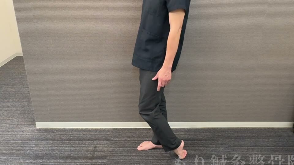 立った状態で足の甲を床につけ、ふくらはぎを縮めるストレッチ(横から見た全身)