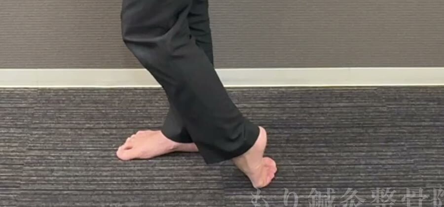 足の甲を床につけ、指を丸めて押しつける足元のアップ